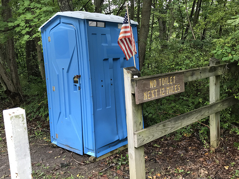 Porta potty on the GAP Trail, with sign that there's not another one for 12 miles