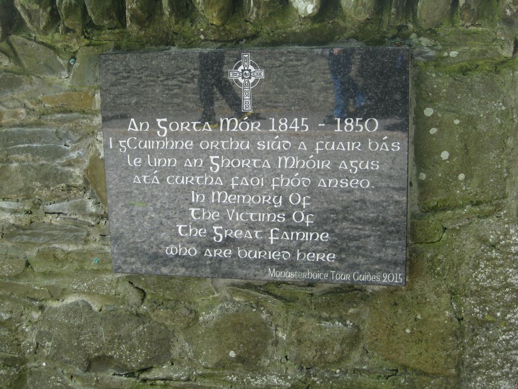 A plaque on the stone wall of the cemetery at Monasterboice remembers those who died during the Great Famine.